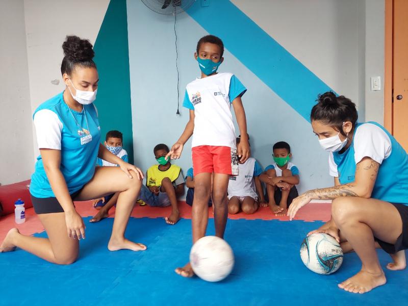 Jogadora e auxiliar dão aulas de Futsal para meninos e meninas no Bairro Educador 